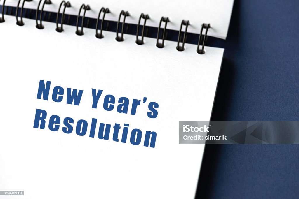 New Year’s Resolution Spiral notepad on yellow background with New Year’s Resolution text. Adhesive Note Stock Photo