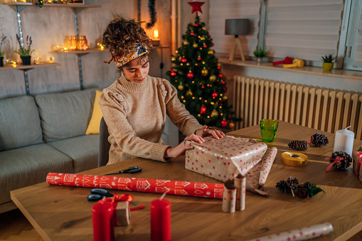 Young woman preparing Christmas presents at home
