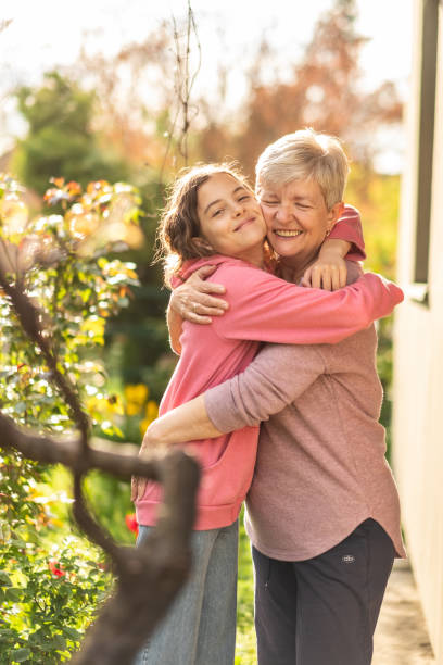 Grandma and granddaughter are hugging Grandma and granddaughter are hugging in the garden teenage girl with grandmother stock pictures, royalty-free photos & images