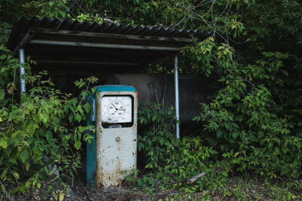velho posto de gasolina abandonado enferrujado coberto com grama e árvores - old station natural gas russia - fotografias e filmes do acervo