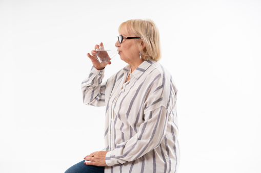 Senior Woman Drinking Water,studio shot