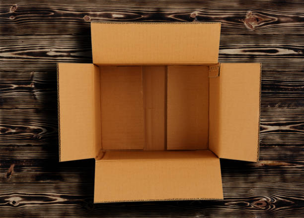 istock Cardboard box on wooden background with shadow. 1435097501