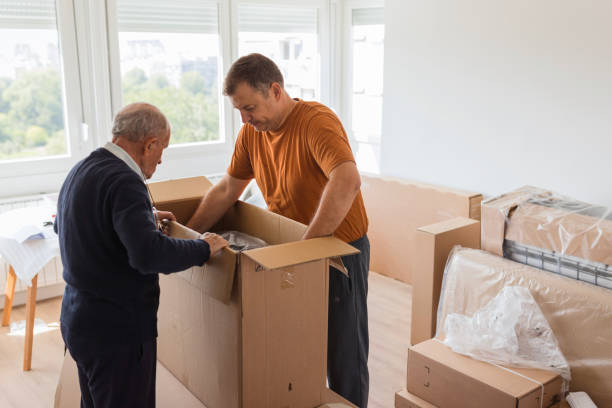 istock Elderly man helping handyman unpack big cardboard box 1435100113