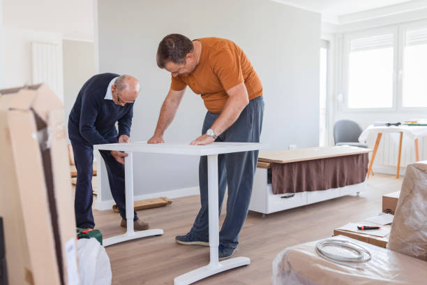 istock Senior man helping his son assemble work station at home 1435100316