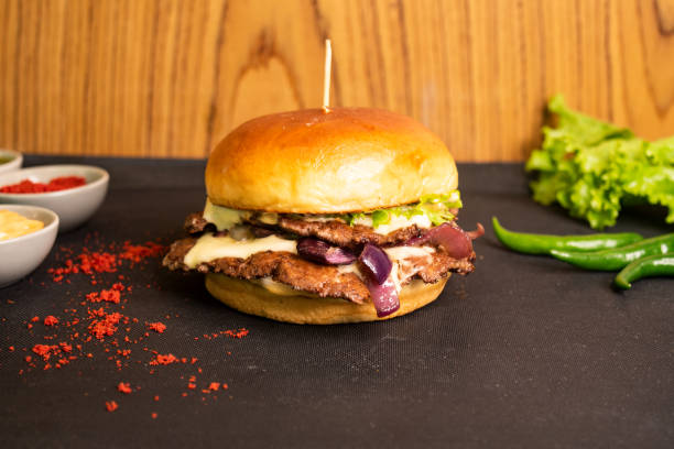 istock Brioche Smash Double Beef Cheese Burger with tomato sauce and green chilli isolated on table side view of fastfood 1435100408