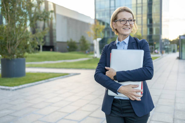 istock Cheerful business woman holding laptop 1435100426