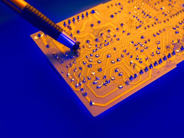 istock Pencil contact cleaner on gold illuminated computer hardware board with solder connections highlighted with blue light 1435101928