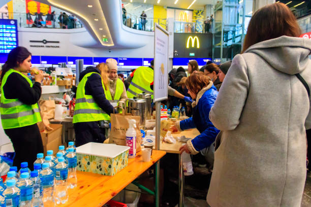 Volunteers help refugees from Ukraine at the railway station in Warsaw, Poland stock photo