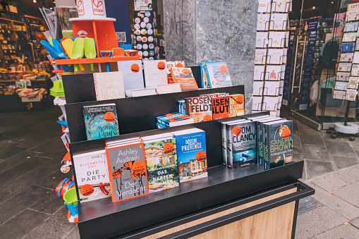 25 July 2022, Osnabruck, Germany: Books and booklets in German for sale on the counter of a bookstore