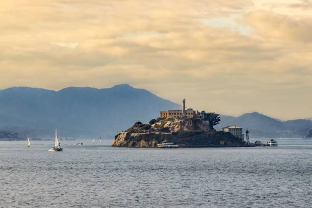 Beautiful scenery of Alcatraz island or "The Rock" under the pinky cloudy sky in San Francisco Bay A beautiful scenery of Alcatraz island or "The Rock" under the pinky cloudy sky in San Francisco Bay, California alcatraz island photos stock pictures, royalty-free photos & images