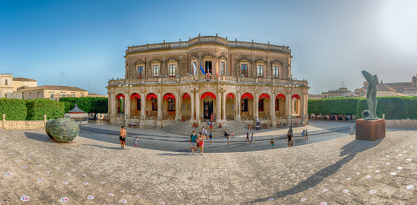 Noto, Italy - August 12, 2021: Facade of Palazzo Ducezio, historical building and major landmark in Noto, picturesque town in Sicily, Italy