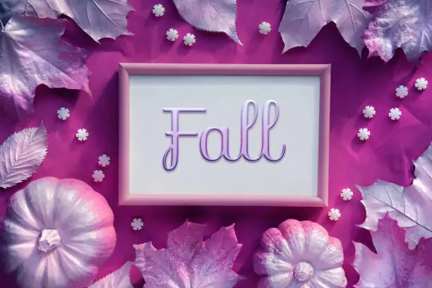Autumn magenta frame with word, caption Fall. Painted maple leaves, pumpkins and rows of sugar sprinkles. Vibrant monochromatic seasonal decor, flat lay, top view.