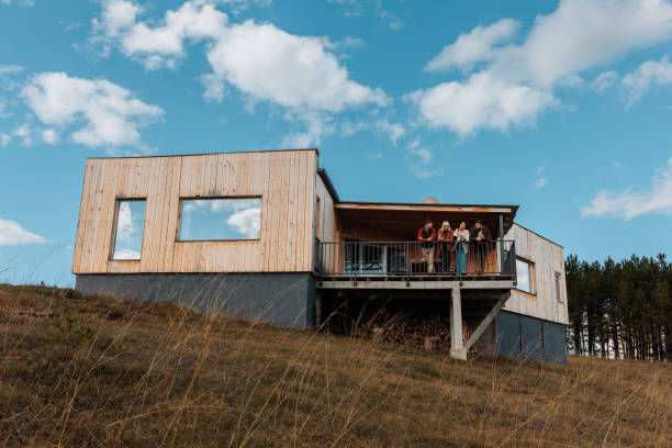 A group of ethnically diverse friends are on a weekend vacation at the mountain. They are in a mountain cabin relaxing on the patio, enjoying the view.