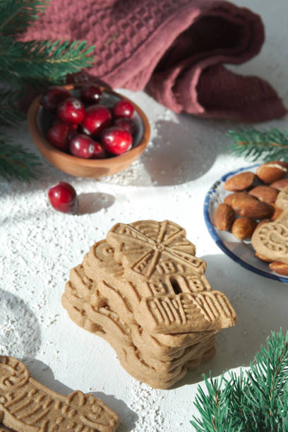istock Speculoos or Spekulatius, Christmas biscuits, with cranberry berries, almonds on a table with kitchen towel and fir twigs. Traditional German sweets and cookies for Christmas or Advent. 1435114525