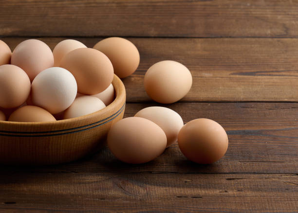 istock Fresh brown chicken eggs in a round wooden plate on the table 1435116460