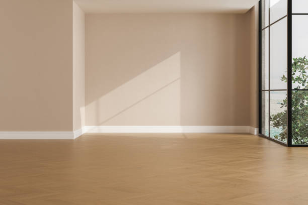 istock Realistic 3D render of room, beautiful sunlight and window frame shadow on beige blank wall, white skirting board in an empty room. New wooden parquet floor. Background, Interior. Front view. 1435122479