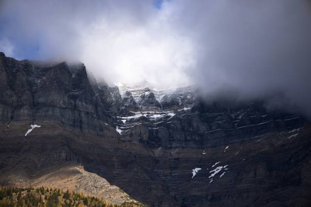 istock Scenic view of rocky mountain peak behind clouds 1435122577