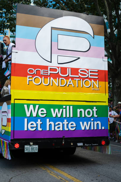 Sign of One PULSE Foundation, LGBTQAI+ members in honor to tragic day on 2016, in the Come Out With Pride Orlando parade 2022 Orlando, Florida, October 15, 2022.  Sign of One PULSE Foundation, LGBTQAI+ members in honor to tragic day on 2016, in the Come Out With Pride Orlando parade on E Central Blvd street. pulse orlando night club & ultra lounge stock pictures, royalty-free photos & images
