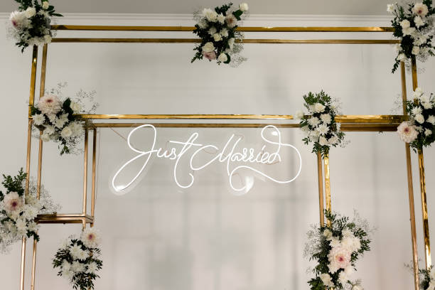 istock wedding rectangular metal gold arch design with fresh white flowers and greens on a white wall background. Festive decoration photo zone indoors 1435125781