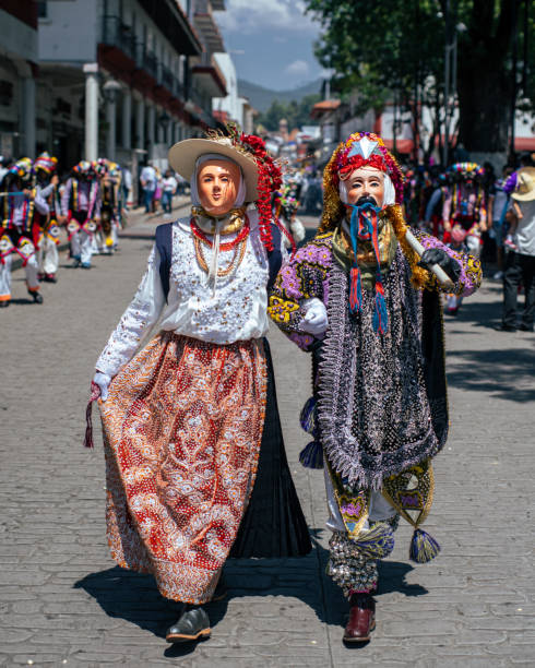 plan vertical d’un couple portant des masques traditionnels mexicains marchant dans les rues lors d’un festival - uruapan photos et images de collection