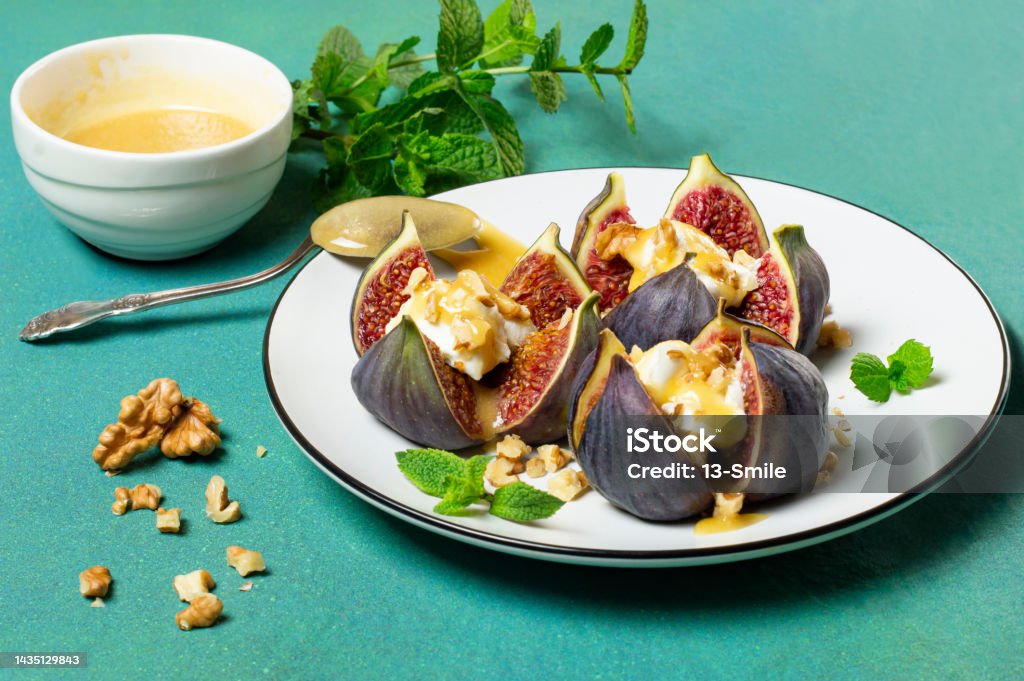 Figs stuffed with cream cheese with honey sauce and walnuts Ripe figs stuffed with cream cheese with honey sauce and walnuts. Delicious appetizer, perfect aperitif or fruity dessert Aperitif Stock Photo