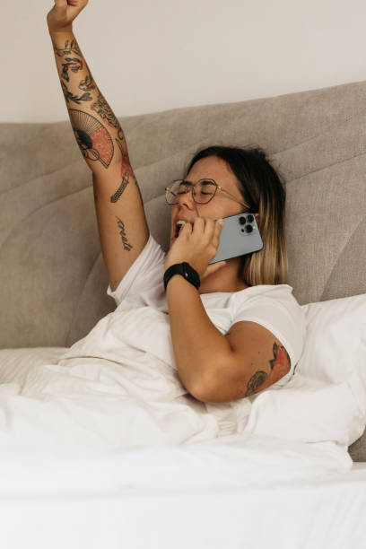 istock Young woman yawning while on a phone call 1435130678