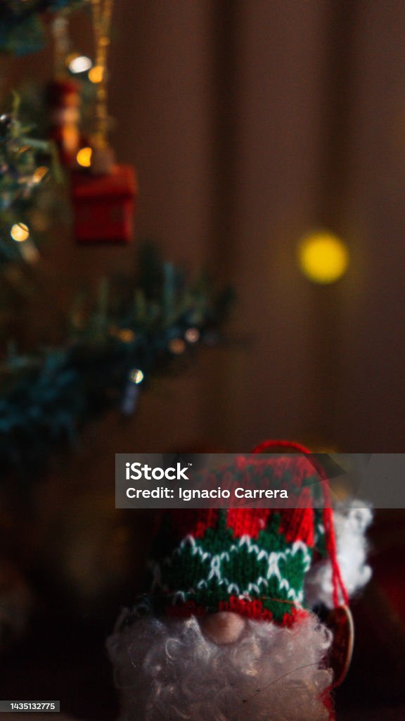 Foto de Boneca De Papai Noel E Decorações De Natal Em Uma Pequena Árvore De  Natal Em Um Tronco Com Luzes E Um Ambiente Quente À Noite Na Véspera Da Boa  Noite
