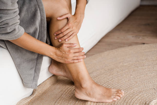 deep vein thrombosis and varicose of african woman. girl touching her legs and looking at veins. sclerotherapy procedure at visiting vascular surgeon doctor. - coágulo imagens e fotografias de stock