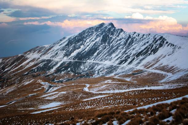 istock A mountain peak covered with snow with a cloudy sky 1435142683