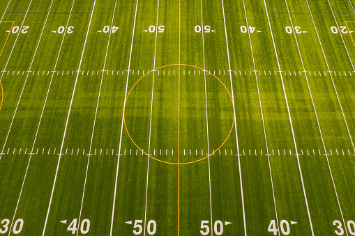 Rugby field grass view. Football field with green grass and white paint lines and marks. Sports soccer and football with nice green environment. Recreational activity ground.