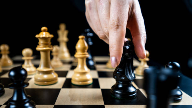 istock Playing chess, female hand moving black knight 1435151213