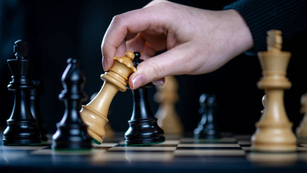 istock Hand holding wooden pieces while playing chess 1435151231