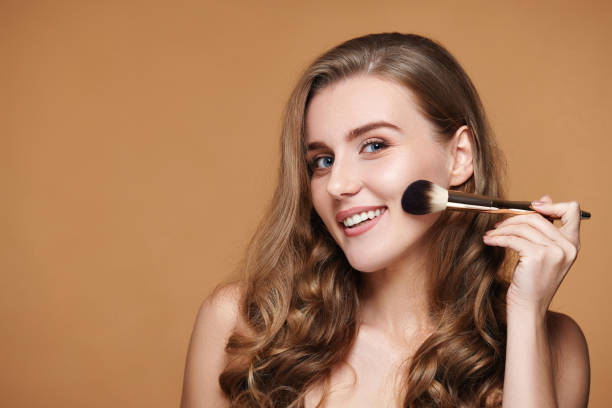 istock smiling woman applying blush on cheeks with make-up brush 1435151762