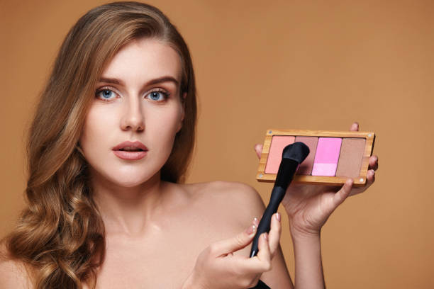 istock woman applying blush on cheekbone with make-up brush 1435151773