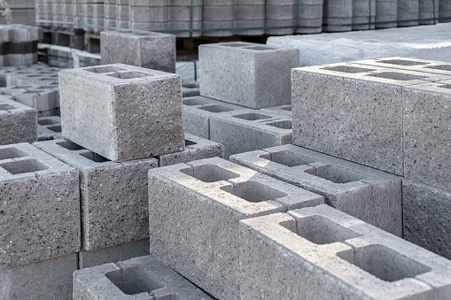 Pallet of Concrete Cinder Blocks, Grey Uniformed brick Shapes building material. New for use on construction site in europe