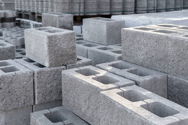 pallet of concrete cinder blocks, grey uniformed brick shapes building material. new for use on construction site in europe - cinza imagens e fotografias de stock