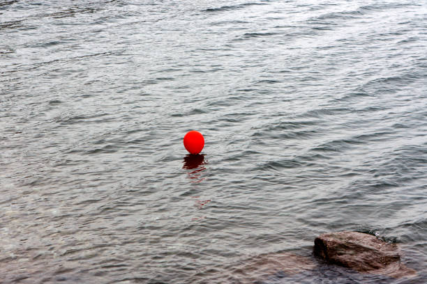 Red balloon in the grey water stock photo