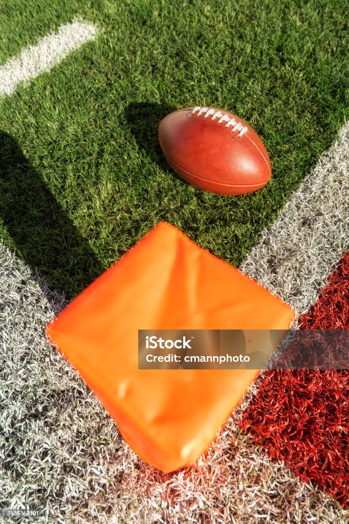 ゴールラインとオレンジ色のパイロンの隣に見られるアメリカンフットボールの高角度ビュー アメフトボールのストックフォトや画像を多数ご用意
