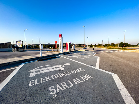 Istanbul, Turkiye, 10/10/2022; Power supply for E-vehicle. Modern outdoor electric car charging station next to the Istanbul - Izmir highway on sunny day. \