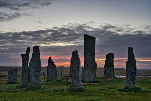 Neolithic stone circle with colourful sunset in sky and clouds