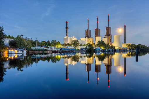 A combined heat and power plant in Berlin at night with a perfect reflection in the water