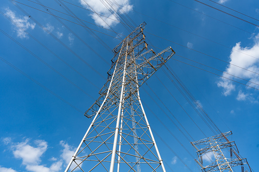 Transmission tower under blue sky and white clouds