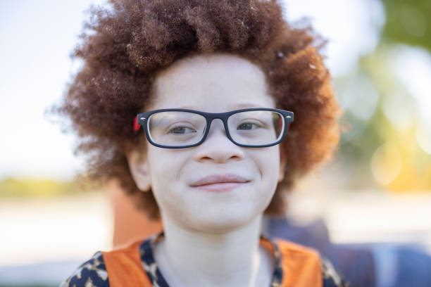 A portrait of a happy African American child with albinism outdoors.