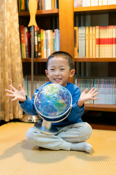 The baby holds the globe