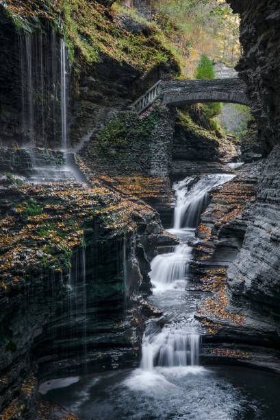 istock Vertical long-exposure scenic view of the waterfalls falling down a cascade under a historic bridge 1435216759