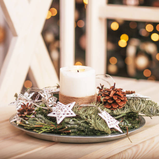 Christmas decoration with candles. Christmas card with holiday mood. Festive burning candles. Natural and reusable decor. Christmas pine tree advent wreath with white candles. stock photo