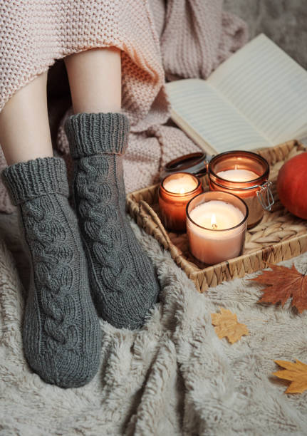 Girl covered with a blanket in knitted socks.