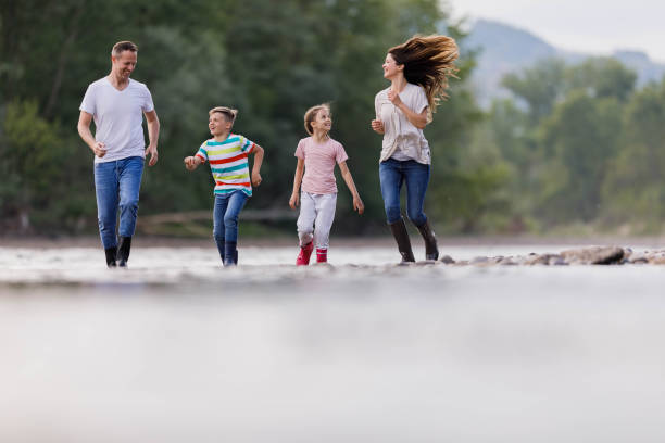istock Happy family having fun while running on the riverbank. 1435224115