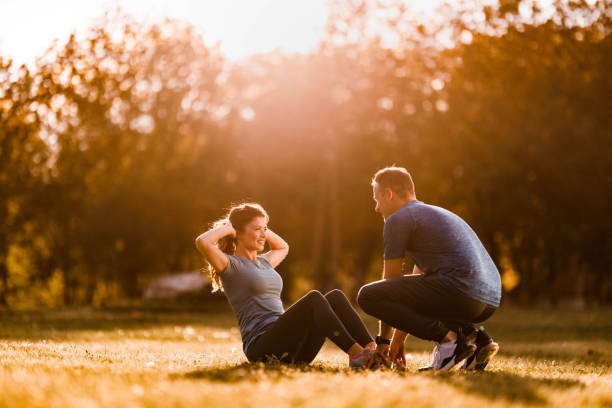 istock Assistance in exercising sit-ups in nature! 1435224306