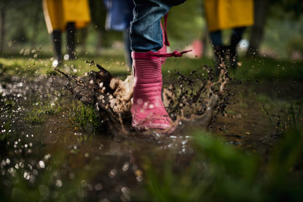 istock Unrecognizable child running through muddy puddle in nature. 1435224781
